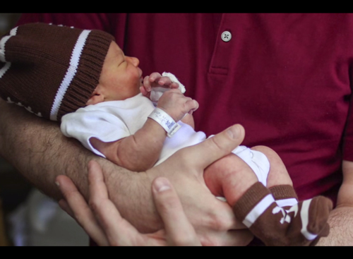 a dad holding a newborn baby